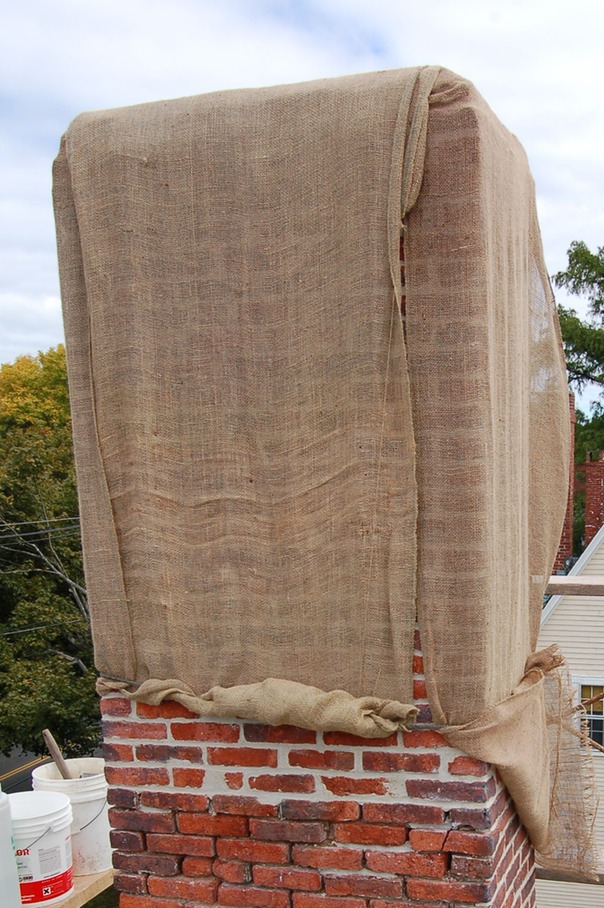 Brick chimney protected with burlap and watered regularly