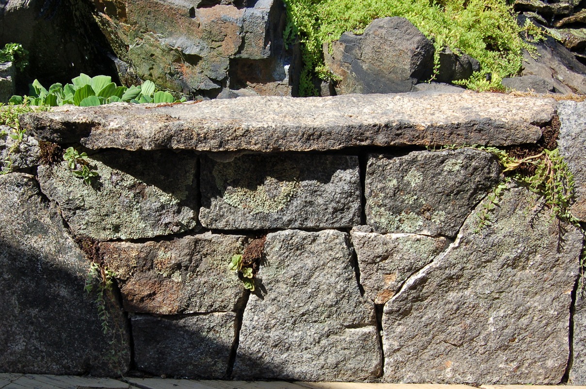 Weathered granite wall with bench stone 