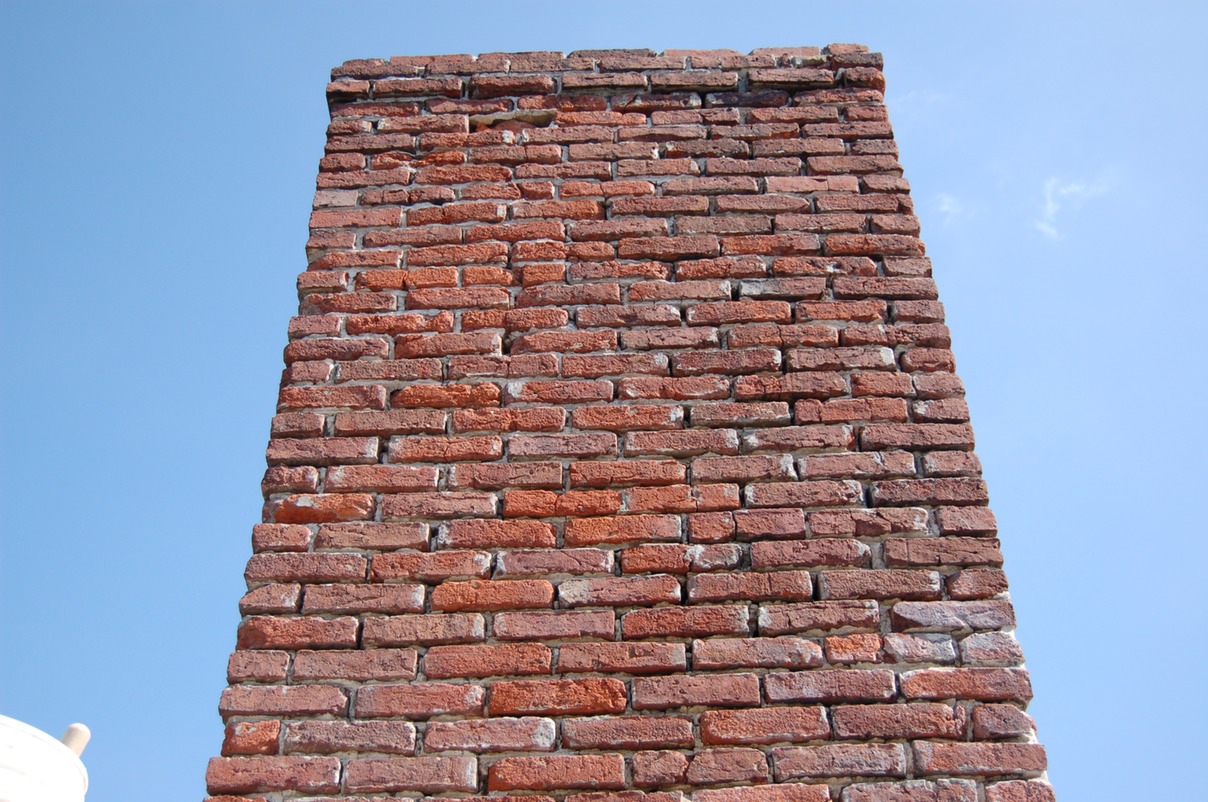 Previous Portland cement mortar repairs on brick chimney removed